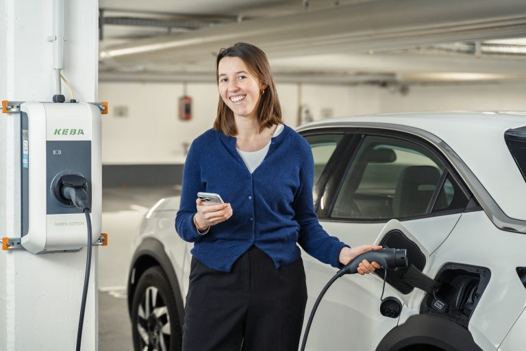 Mieterin lädt E-Auto an LAN1-Wallbox in der Tiefgarage eines Mehrfamilienhauses – Laden per Smartphone am eigenen Stellplatz.